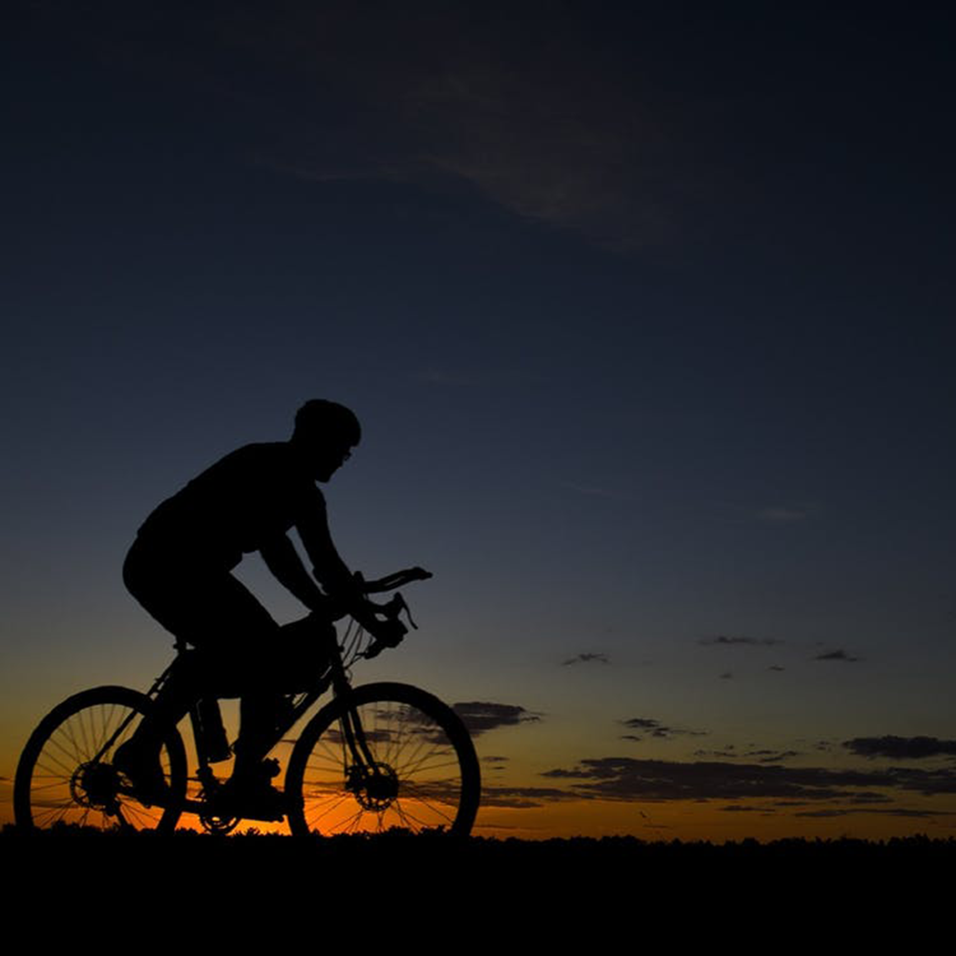 Cyclist silhouetted against sunset